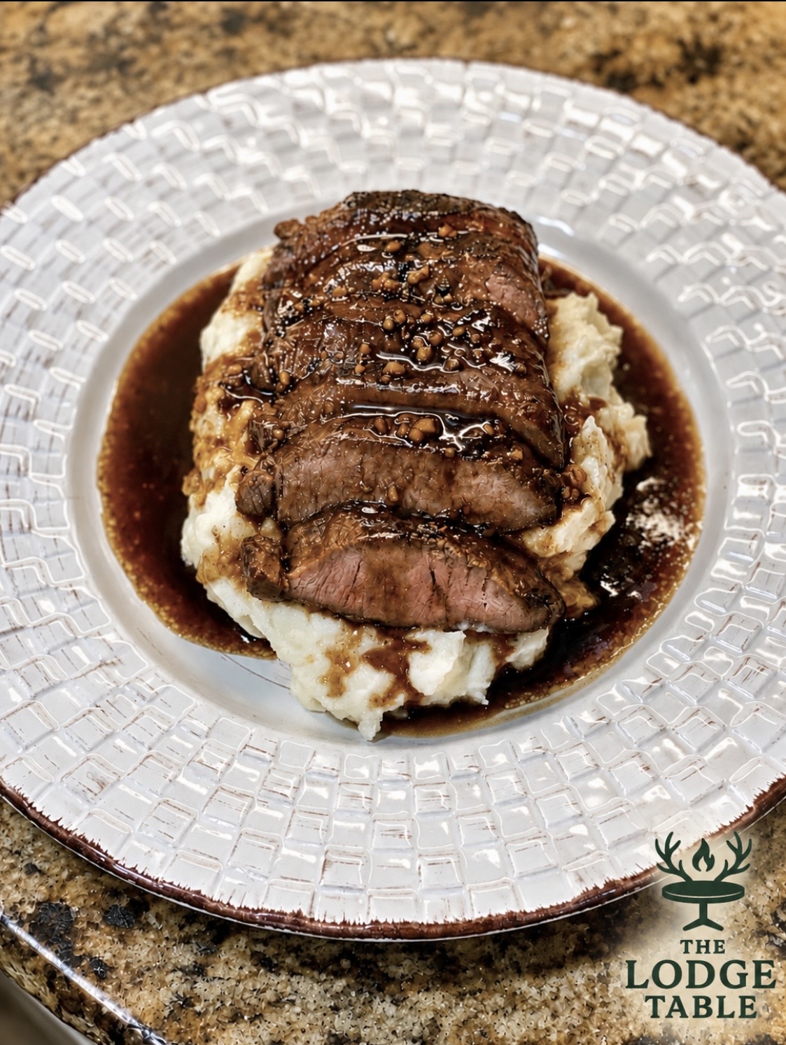 A plated venison meal with bourbon sauce